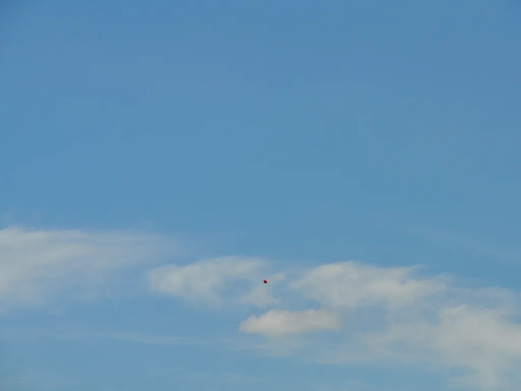 Blauer Himmel mit einem geworfenen Ball.